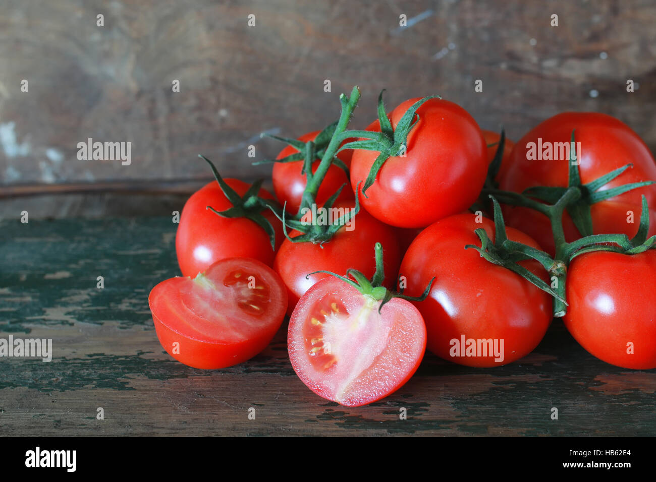 branch of tomatoes on wooden background Stock Photo - Alamy