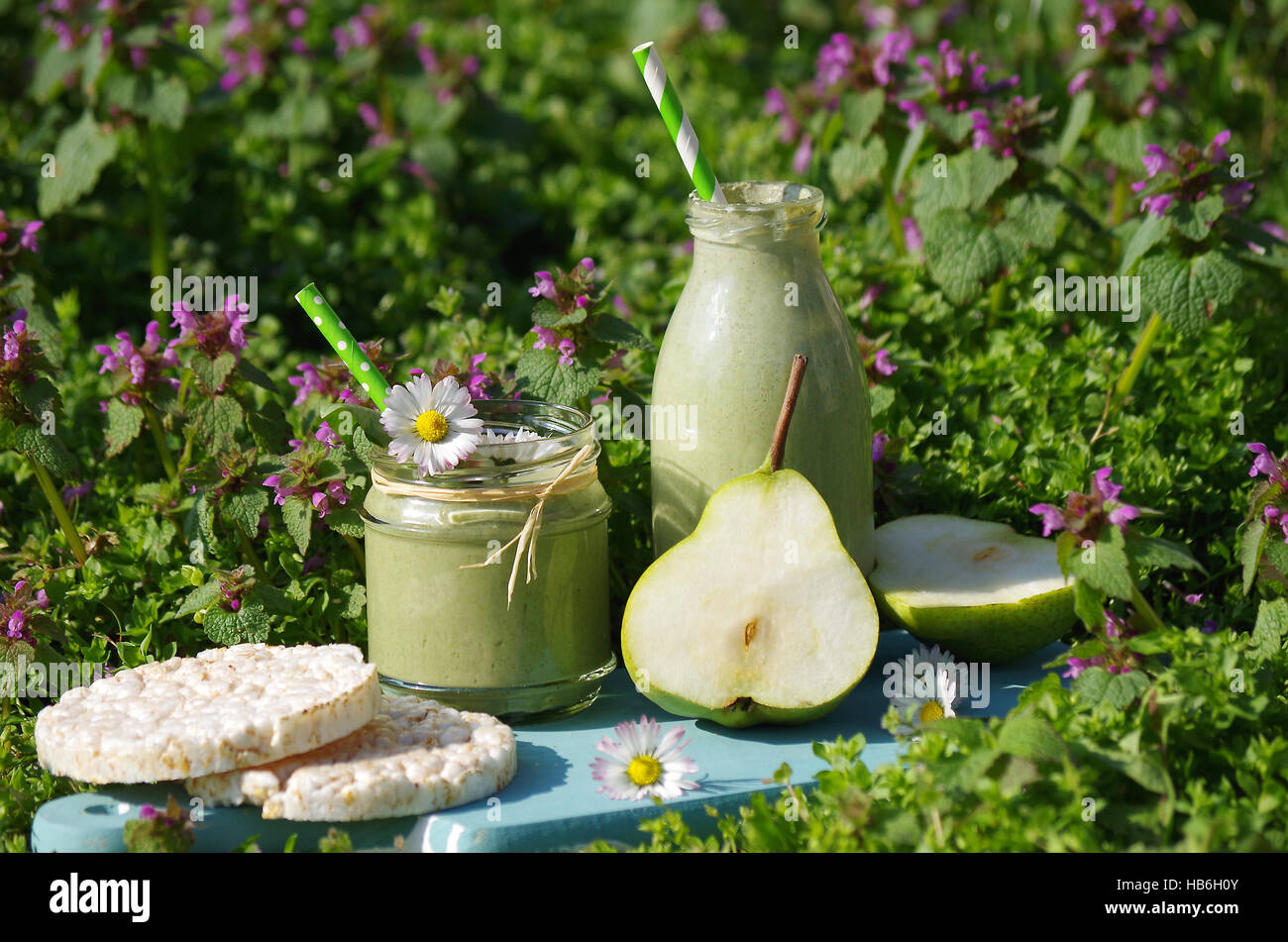 Green smoothie with edible flowers and fruits hires stock photography