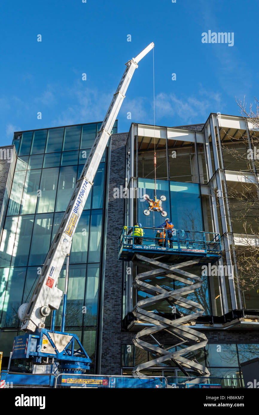 The 'Bright' building under construction 2016.  Manchester Science Park, Pencroft Way, Manchester, UK.  Fitting glass panel. Stock Photo