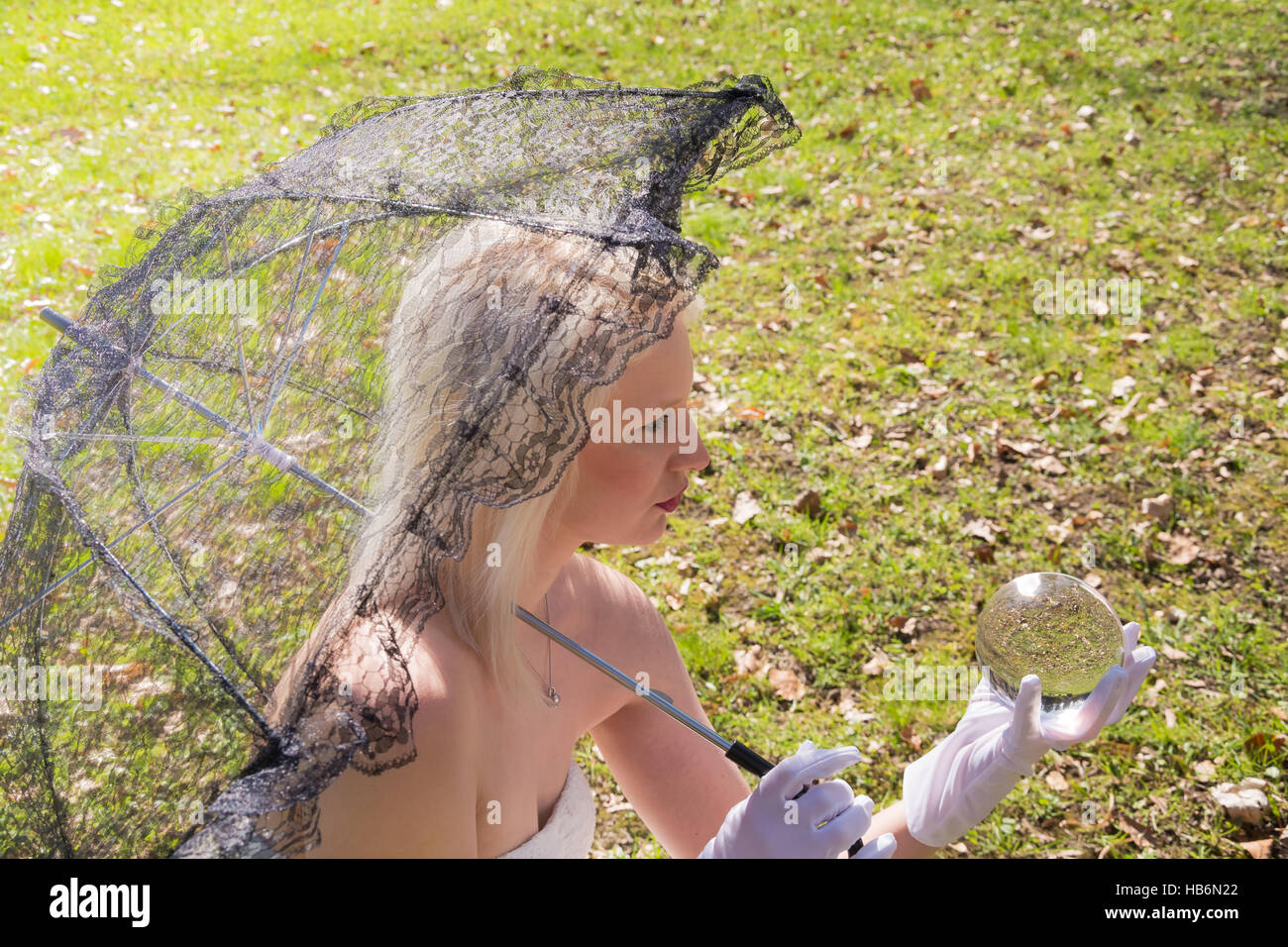 Woman with lace umbrella and glass ball Stock Photo