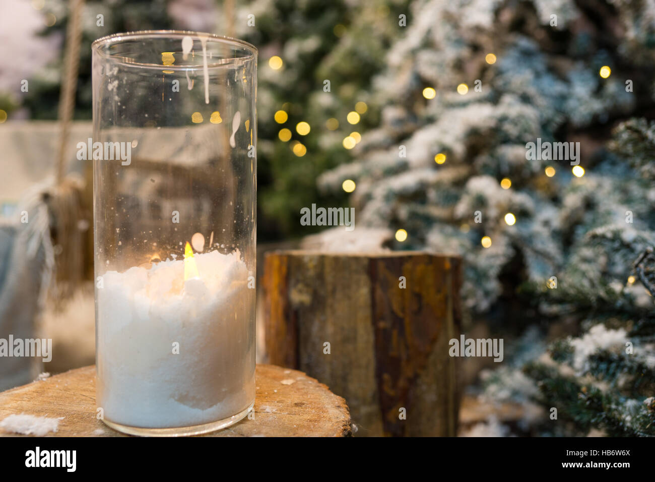 Big candles in glass vases in a snowcovered park or a forest while