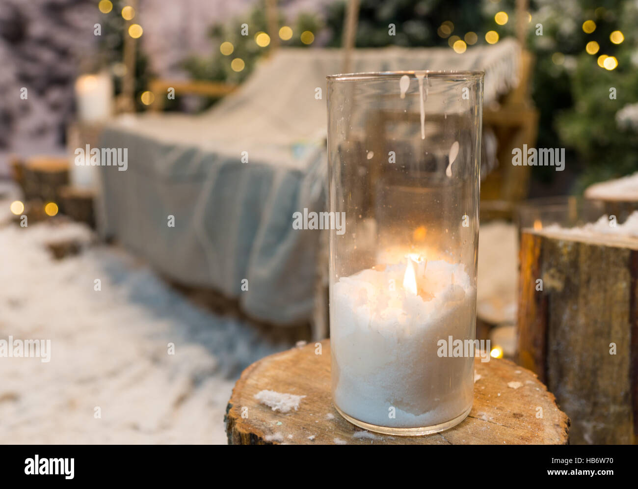 Close up of big candles in glass vases in a snowcovered park or a