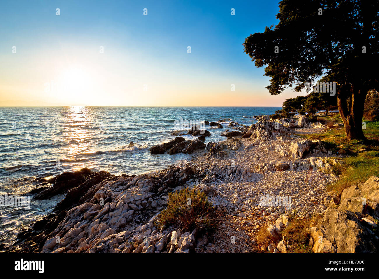 Rocky beach at low sun in Croatia Stock Photo