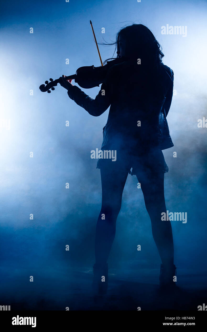 Silhouette of a Rock Woman with Leather Jacket Playing a Violin Stock Photo