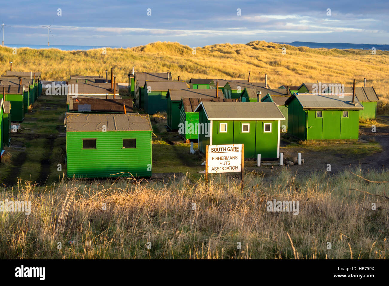 Green fisherman's huts at the South Gare Teesmouth, England UK with Sign South Gare Fishermans Huts Association Stock Photo