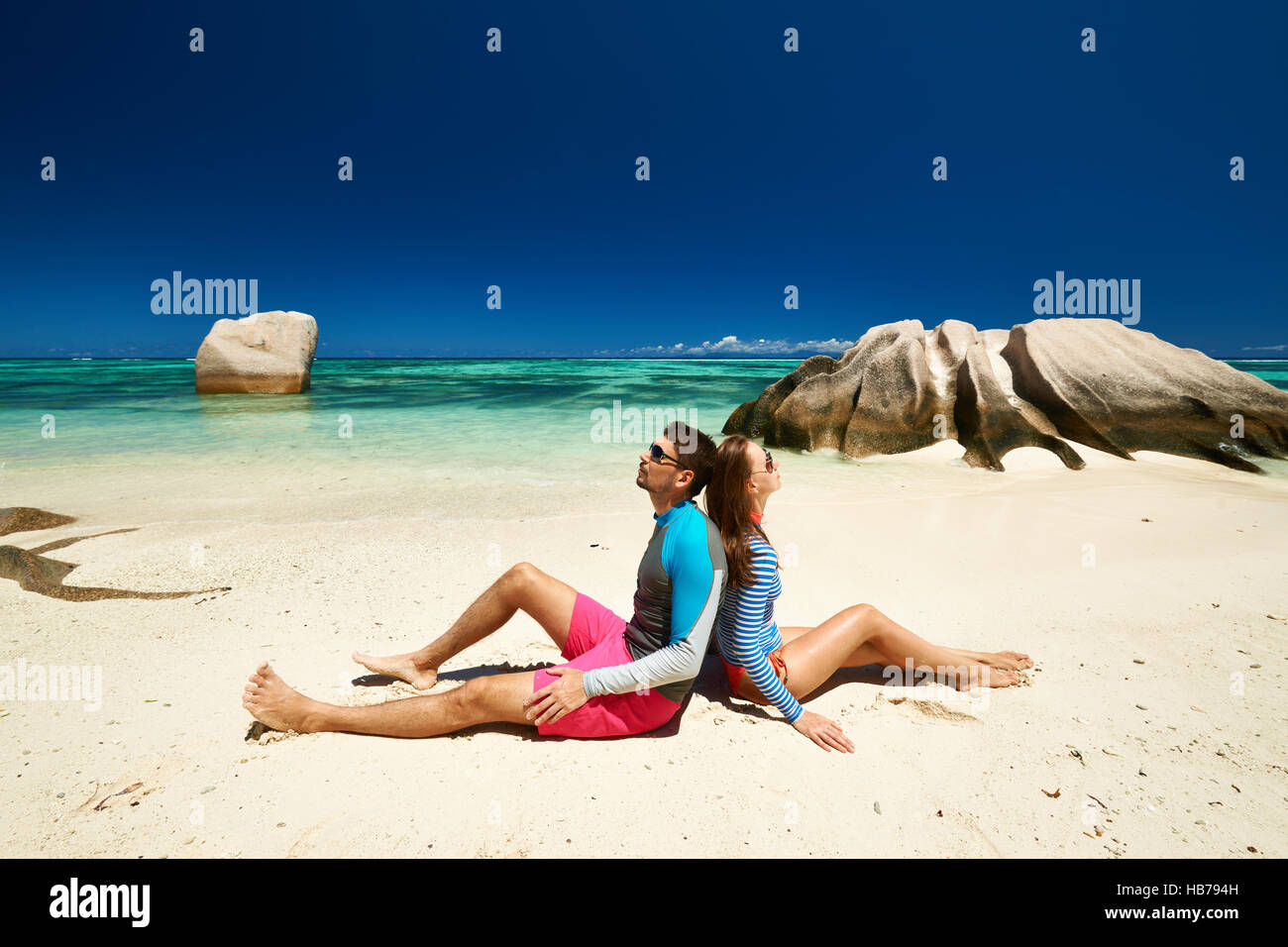 Couple at tropical beach wearing rash guard Stock Photo Alamy