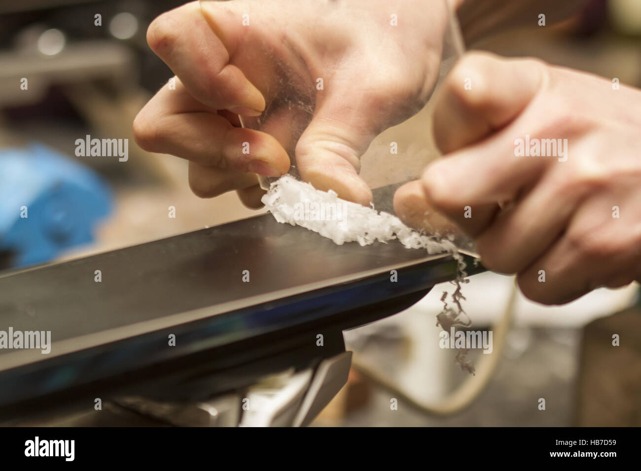 removing excess wax from race ski base with plastic scraper Stock Photo