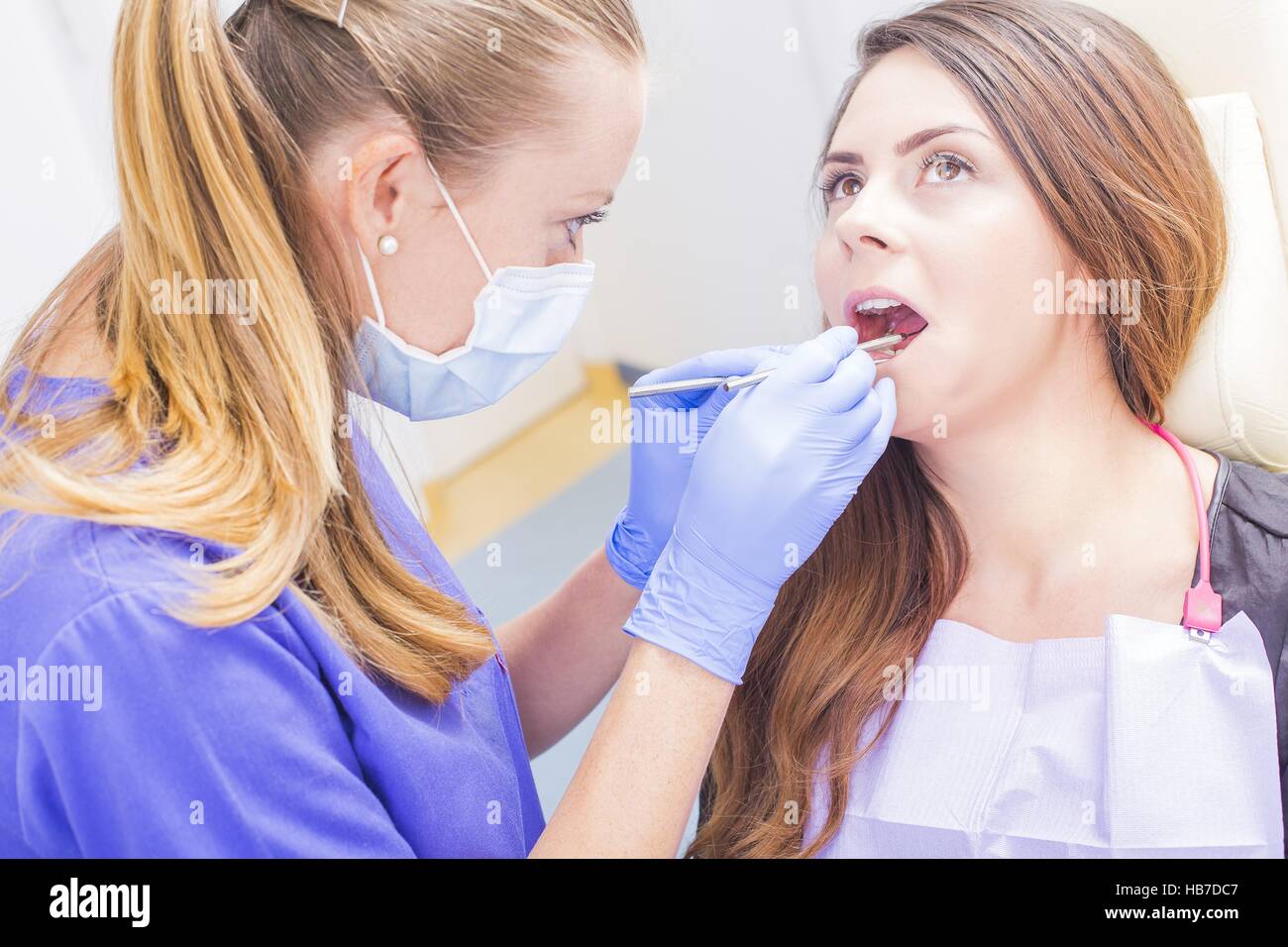 Dentist filling patients cavities with spacial dental tools. Stock Photo