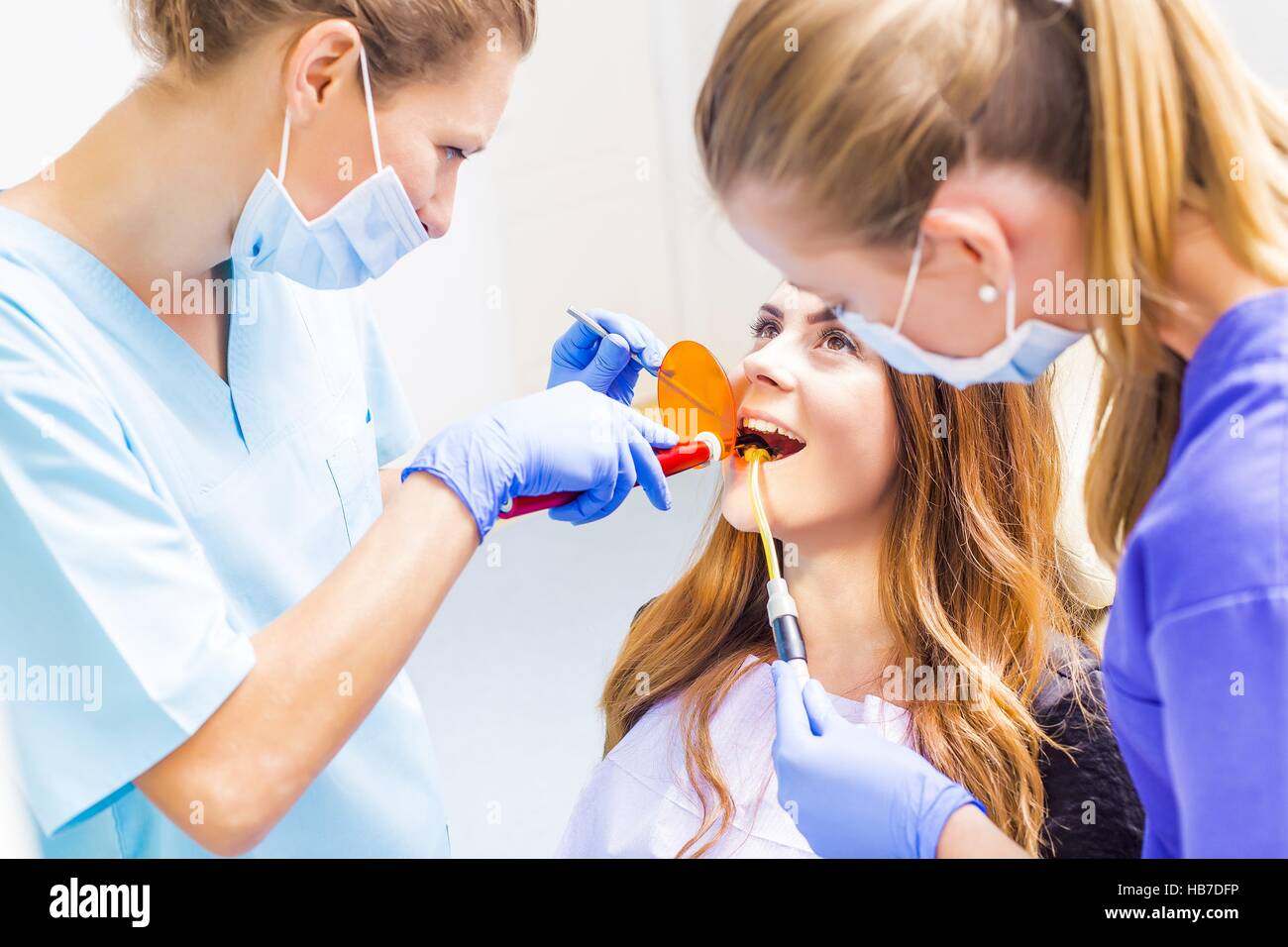 Dentist filling patients cavities with spacial dental tools Stock Photo