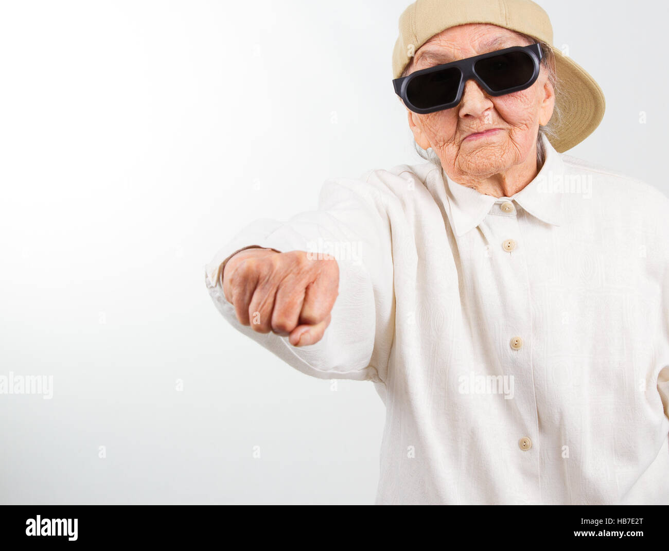 Funny grandma's studio portrait wearing eyeglasses and baseball