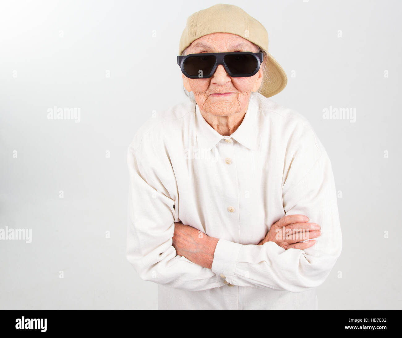 Funny grandma's studio portrait wearing eyeglasses and baseball