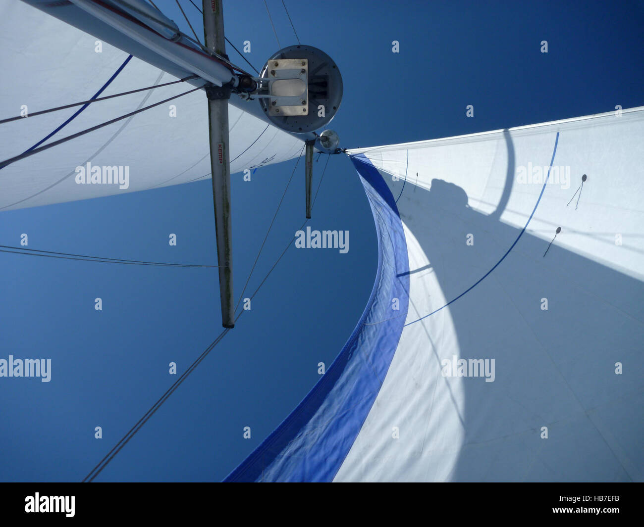 Looking up a yacht mast with main and genoa sails set perfectly to beautiful Pembrokeshire blue sky. Stock Photo