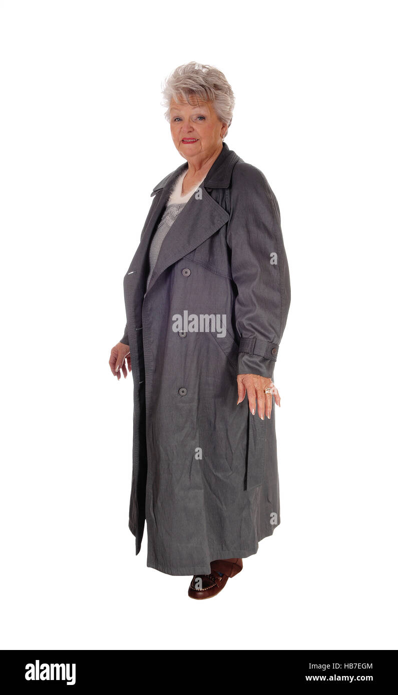 Senior woman standing in a long coat. Stock Photo