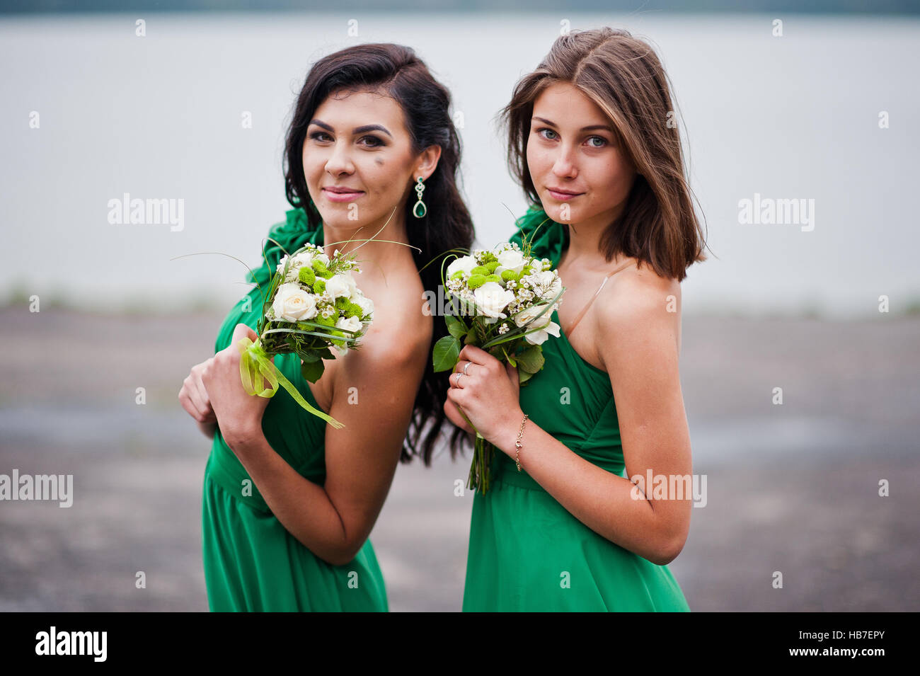 Two charmed girls bridesmaids on green dress Stock Photo
