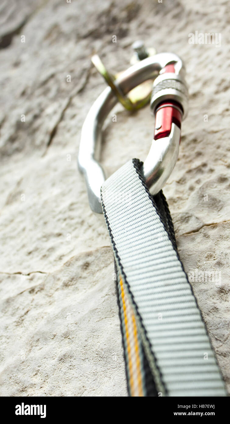 Climbing carabiner on rock wall Stock Photo Alamy