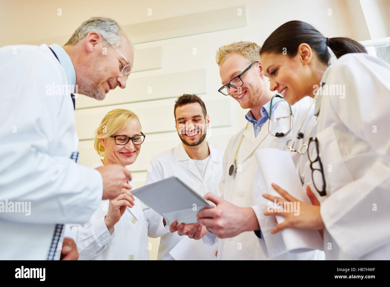Team of doctors with tablet cooperating with joy Stock Photo