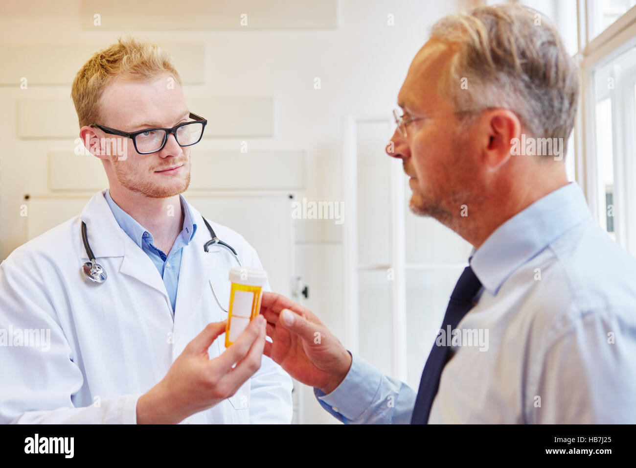 Doctor gives medicament to senior patient for treatment Stock Photo