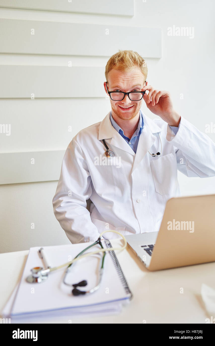 Doctor with laptop at place of work in medical clinic Stock Photo