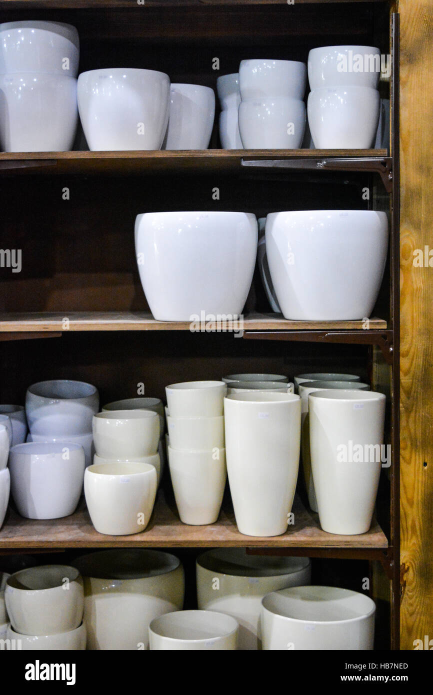 Stylish empty flower pots on wooden shelf indoor in shop Stock Photo