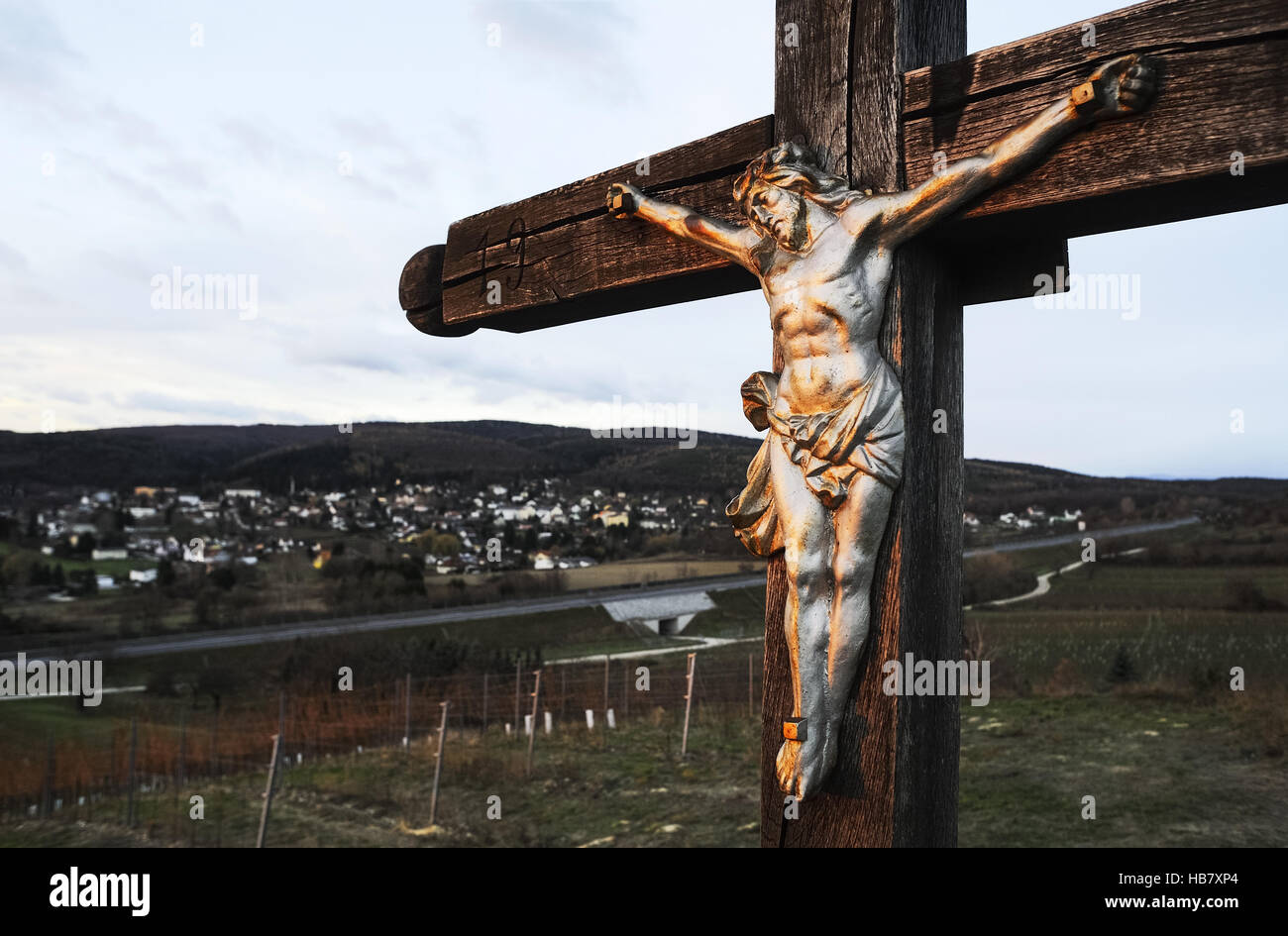 Christ on the Cross watches over a town Stock Photo