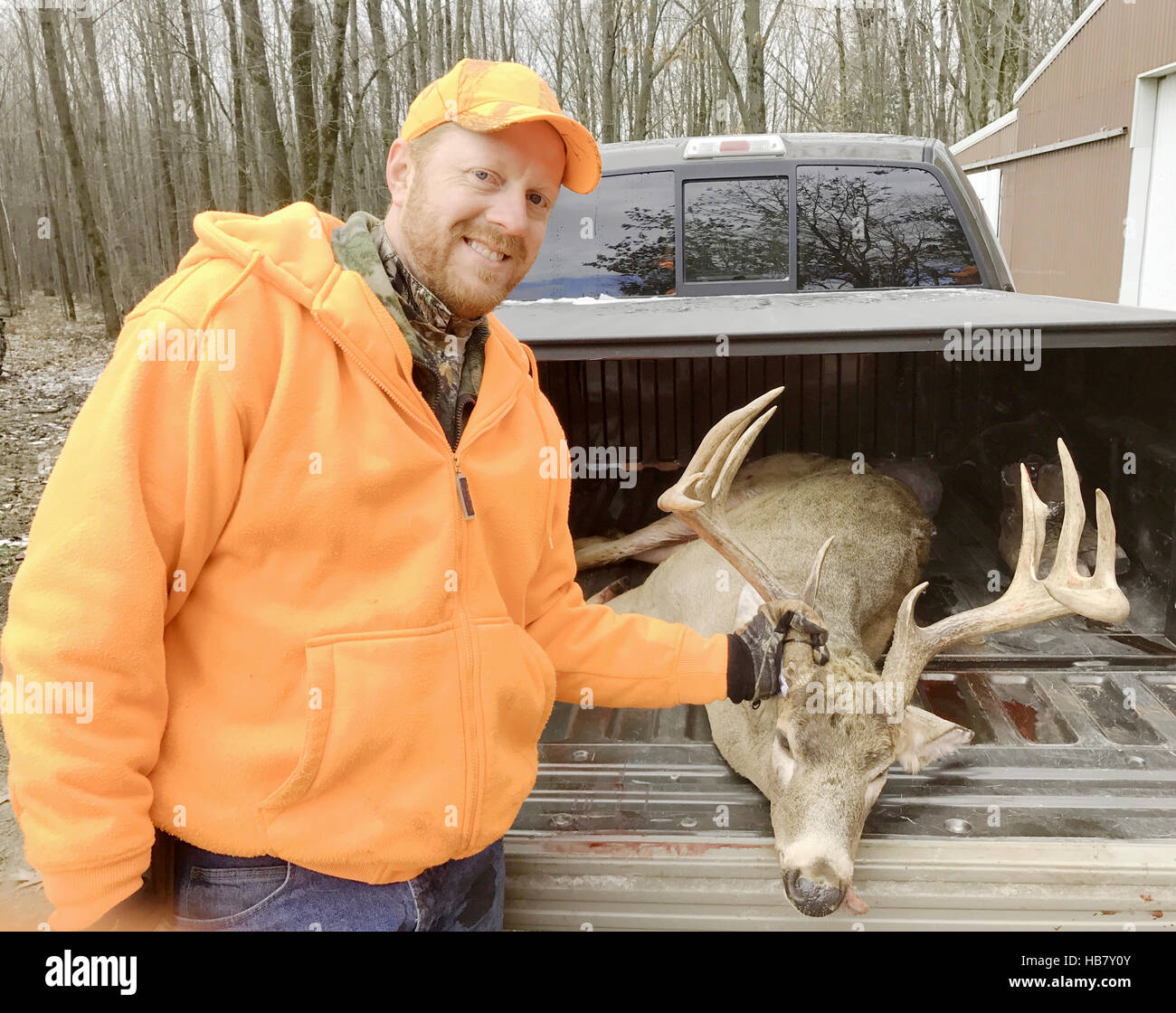 Deer hunter in blaze orange with an eleven point buck Stock Photo Alamy