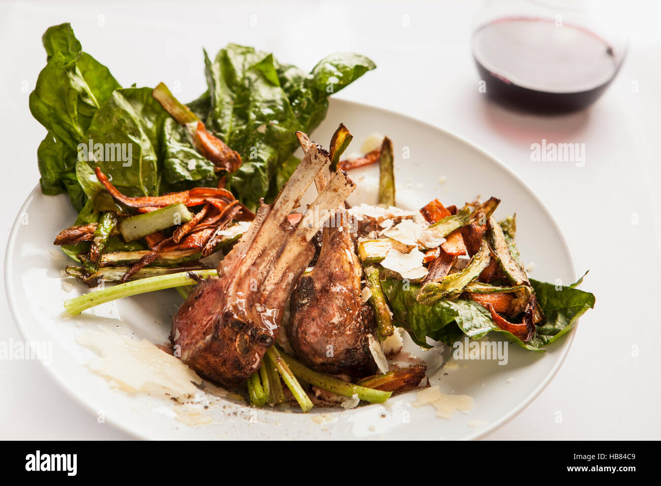 roasted lamb chops and vegetables with a glass of pinot noir Stock