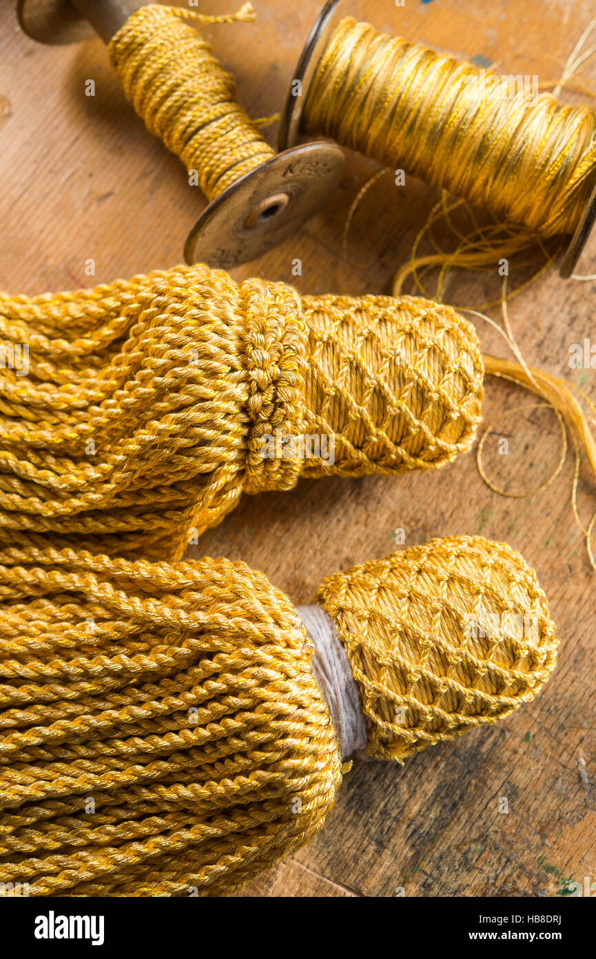Passementerie, semi-finished and finished tassels for end of stair rope, golden silk thread reels, Munich, Bavaria, Germany Stock Photo