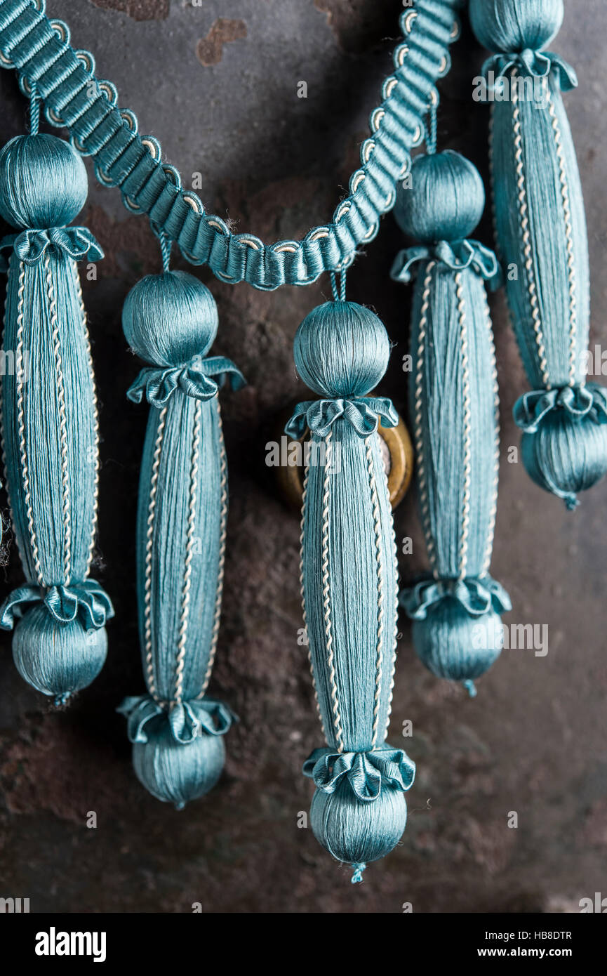 Passementerie, five finished Empire fringes, turquoise, silver, decorated with spun vellum flowers, attached to crepine or woven Stock Photo
