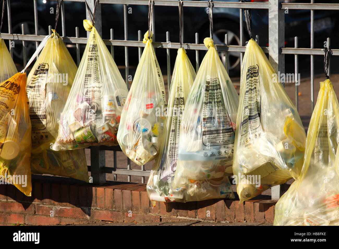 Yellow bags with plastic waste, hanging on garden fence, waste separation, Lower Saxony, Germany Stock Photo