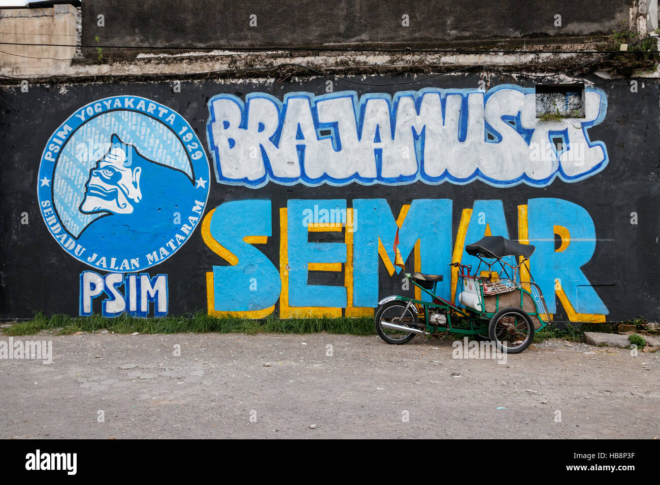 Street art in Yogyakarta with a parked ojek. The street art in