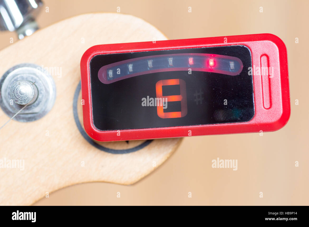 Series of tuning a guitar, E, out of tuning by a digital tuner Stock Photo