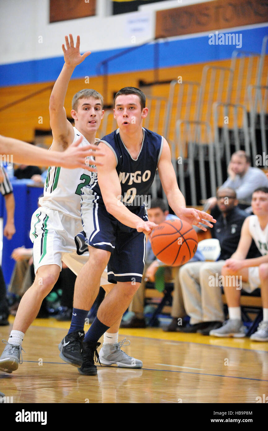 Player dishing off a pass to a teammate from an offensive corner during a high school basketball game. USA. Stock Photo