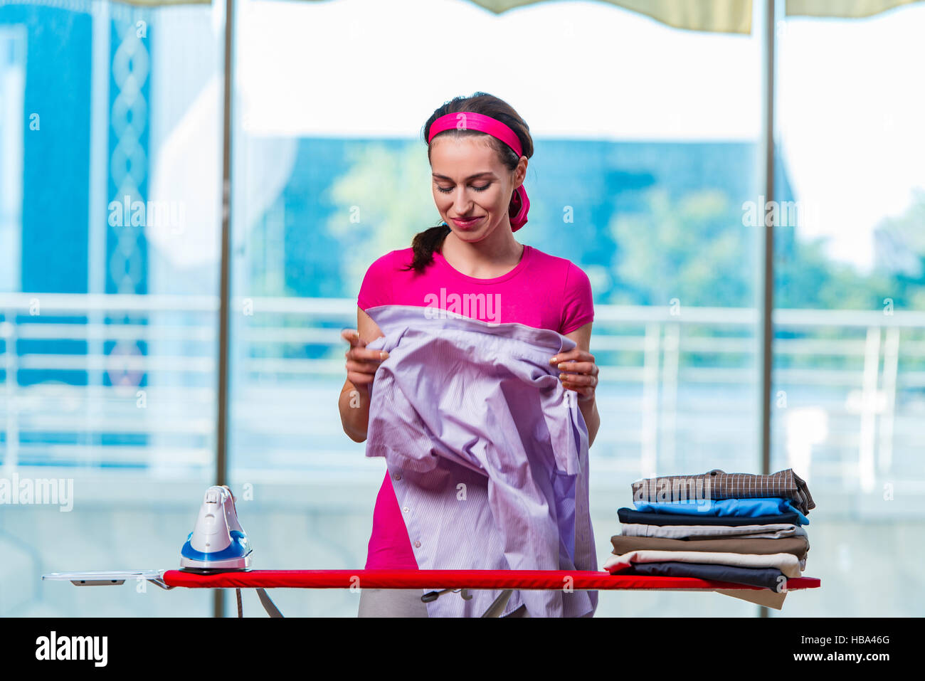 Young woman ironing clothing on board Stock Photo Alamy