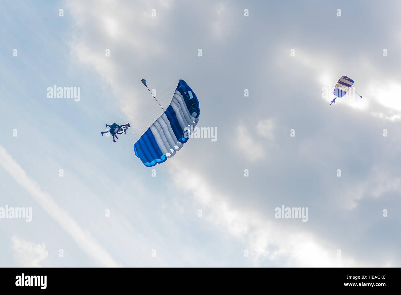 Skydiving is kind of a sport involving a skydiver to jump down from an airplane while it is flying and parachuting to the ground Stock Photo