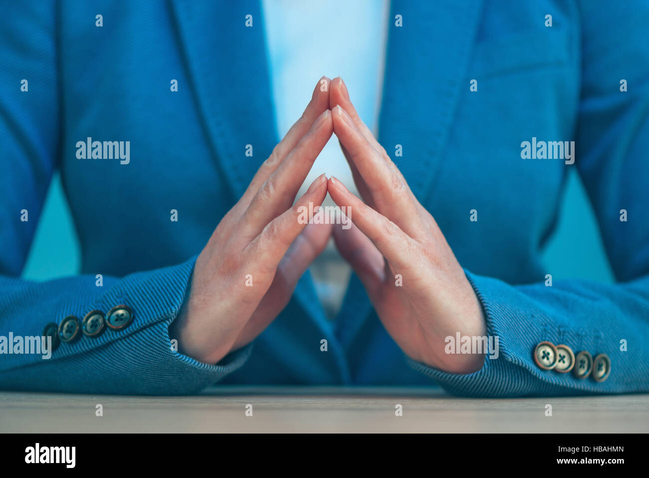 Steepled fingers of business woman as hand gesture sign of confidence, self-esteem, power and domination. Stock Photo