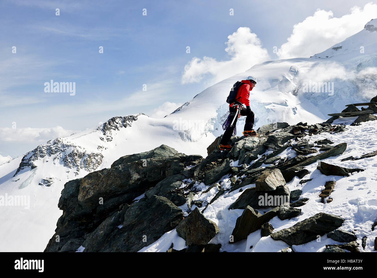 Man climbing up snow covered mountain, Saas Fee, Switzerland Stock Photo