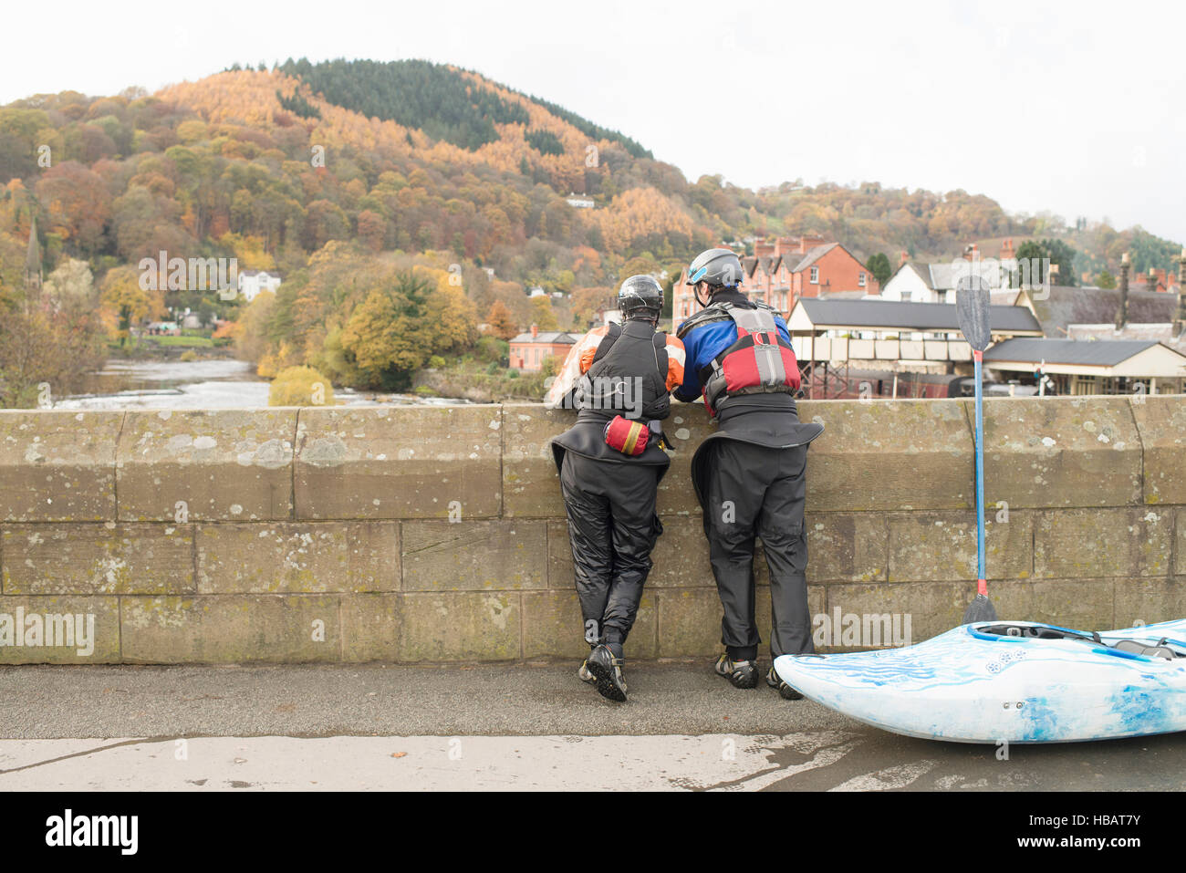 Rear view of two kayakers looking out from bridge on River Dee, Llangollen, North Wales Stock Photo