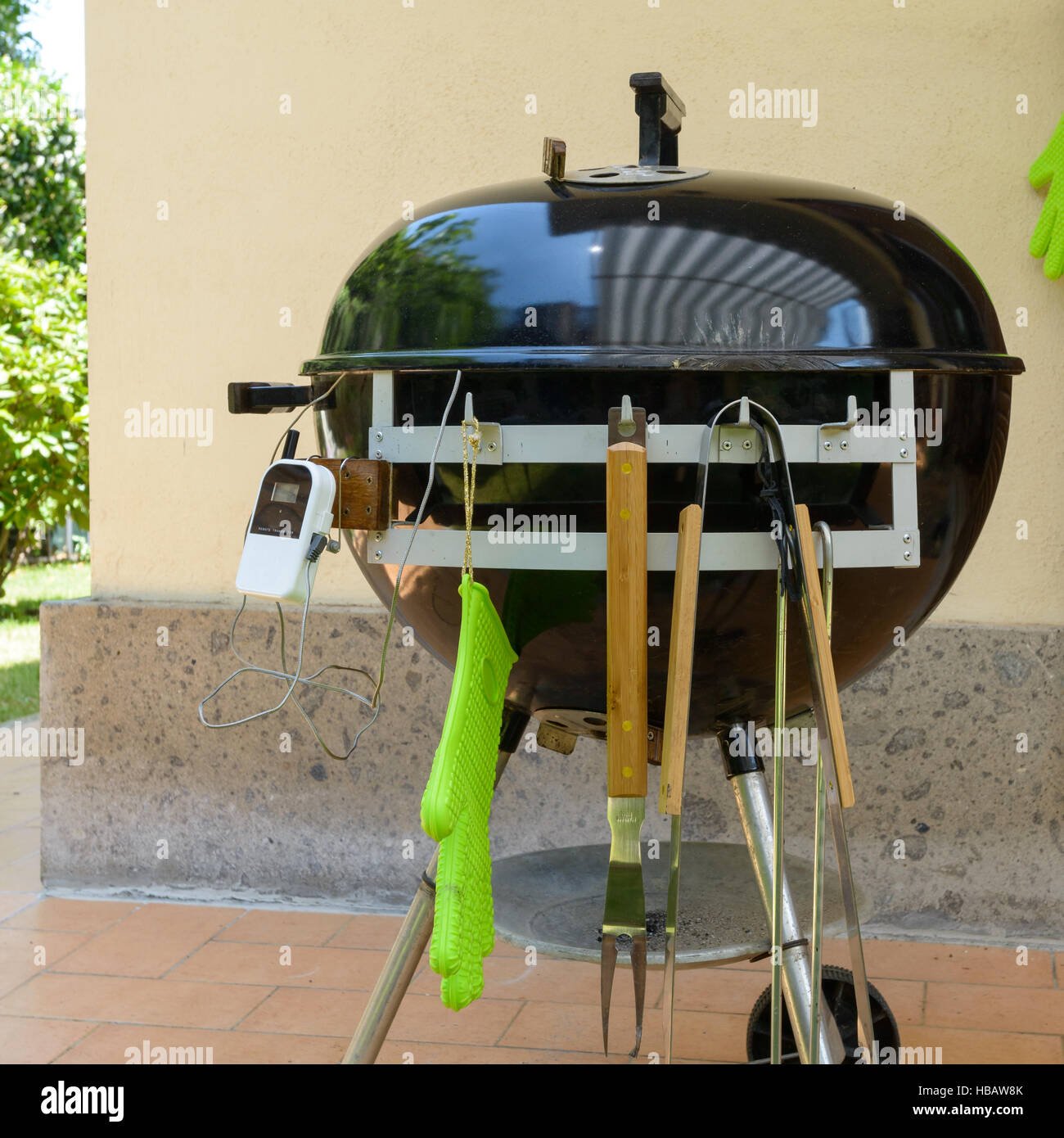 A closed barbecue during pulled pork cooking day, with tools Stock Photo