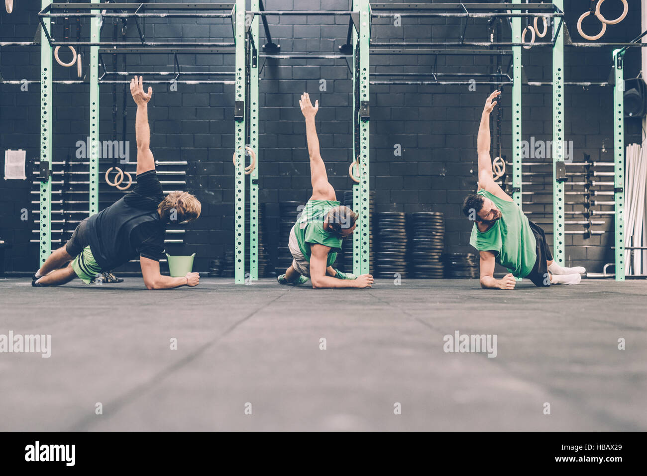 Three male cross trainers doing side push ups in gym Stock Photo Alamy