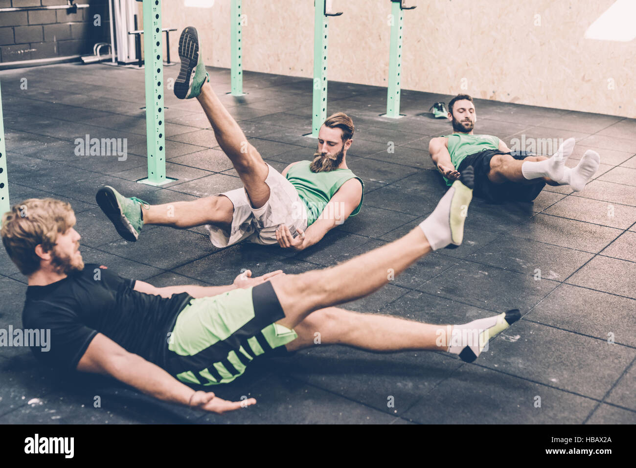 Three male cross trainers doing warm ups in gym Stock Photo Alamy