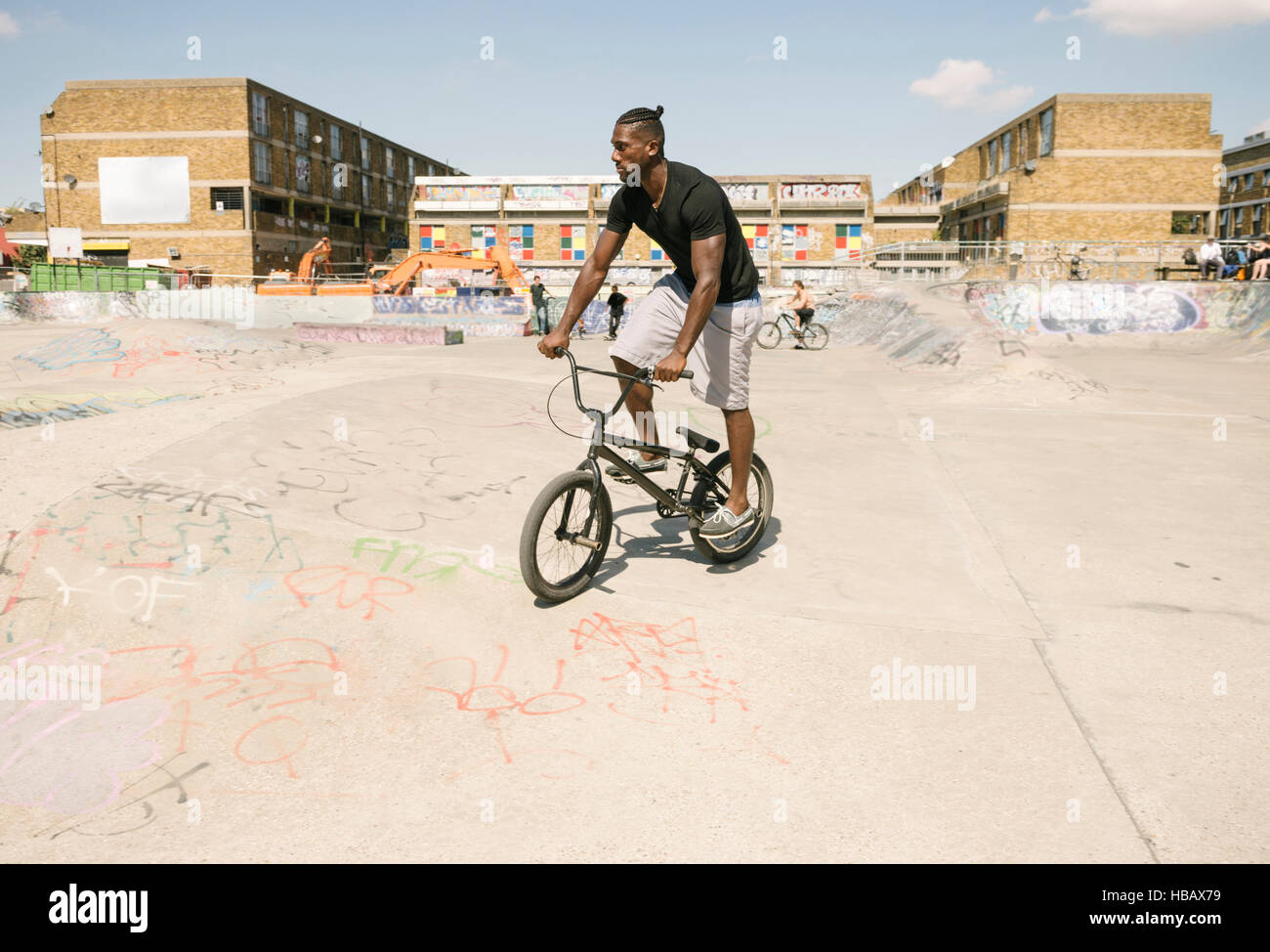 Young man riding BMX bicycle in skatepark Stock Photo