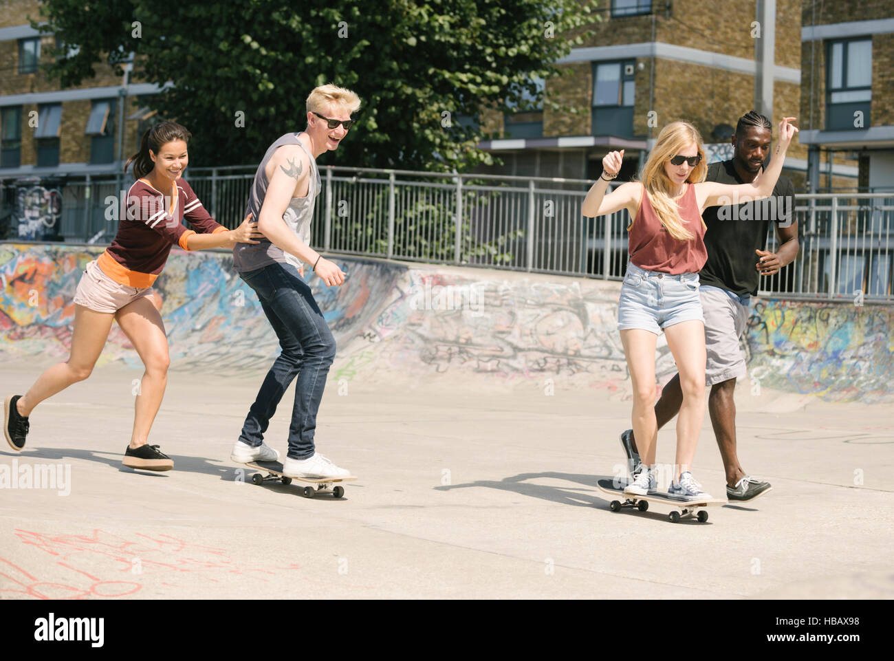 For adult friends learning to skateboard in skatepark Stock Photo - Alamy