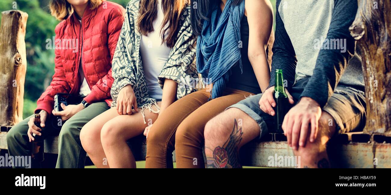 Friends Sitting in a Row Outdoors Concept Stock Photo - Alamy