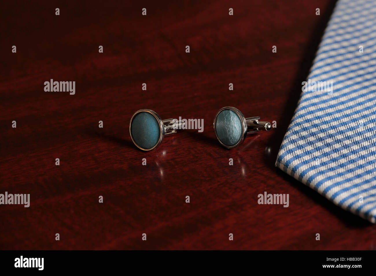 Cuff links and tie on mahogany wooden background Stock Photo