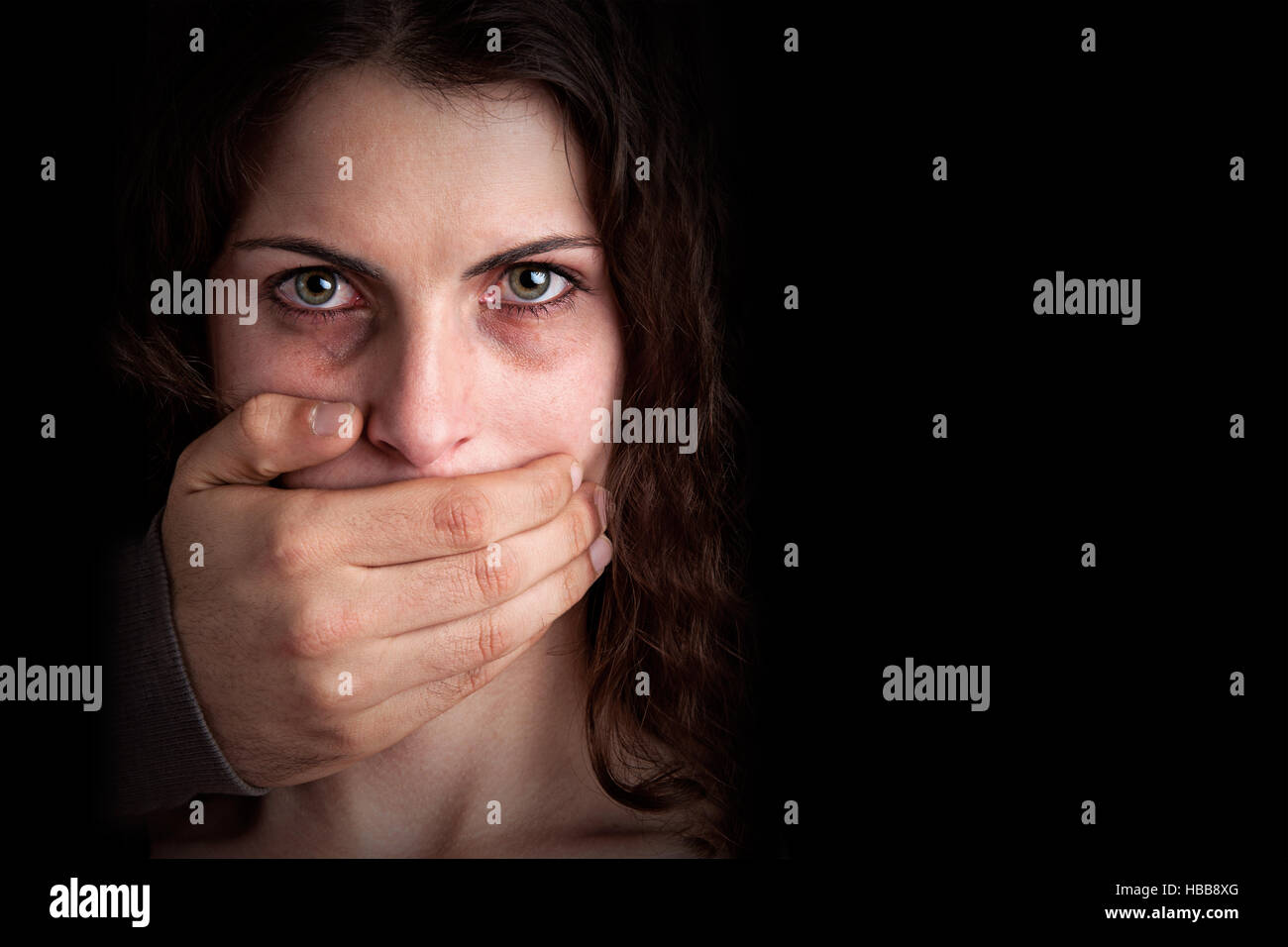 Woman Silenced by Aggressive Husband Stock Photo
