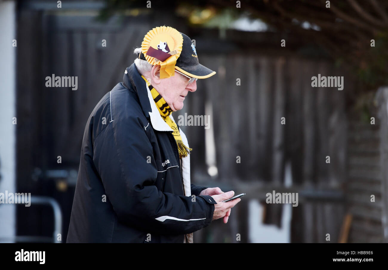 Male fan wearing a Sutton United Football Club rosette on his hat for FA Cup match Stock Photo