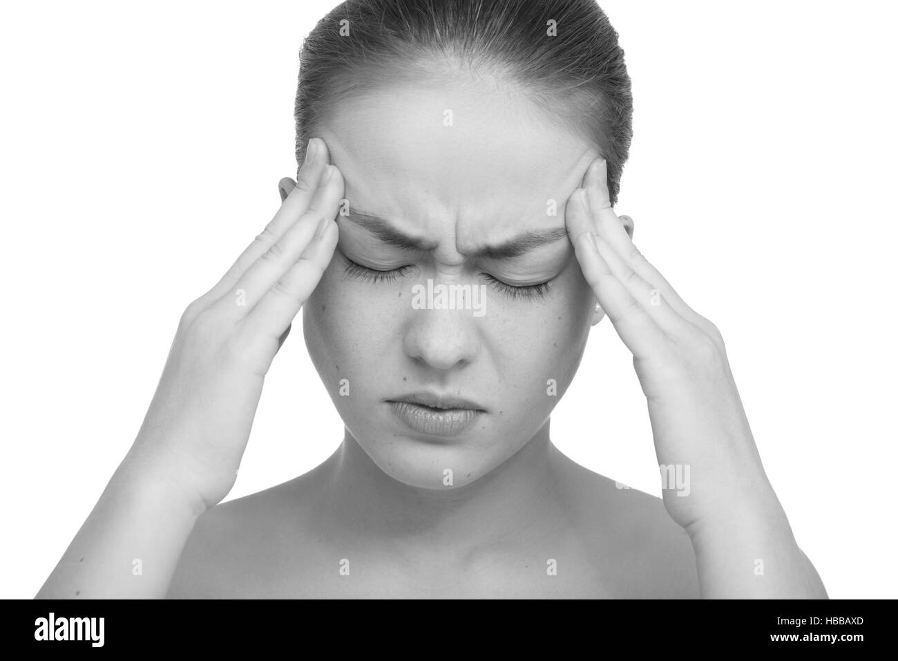 Beautiful young woman with headache touching her temples, isolated in white monochrome image Stock Photo