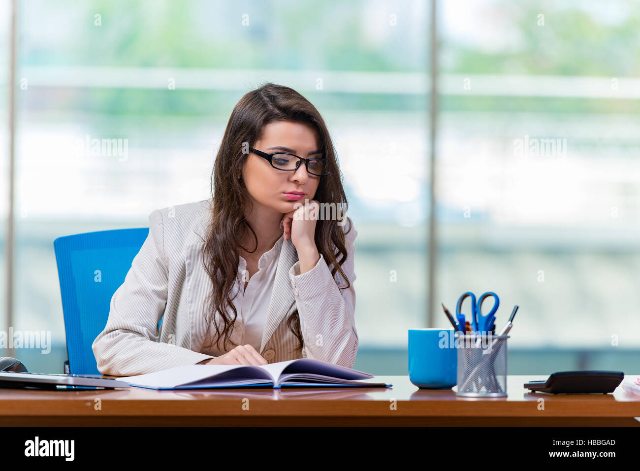 Businesswoman sitting at the office desk Stock Photo - Alamy