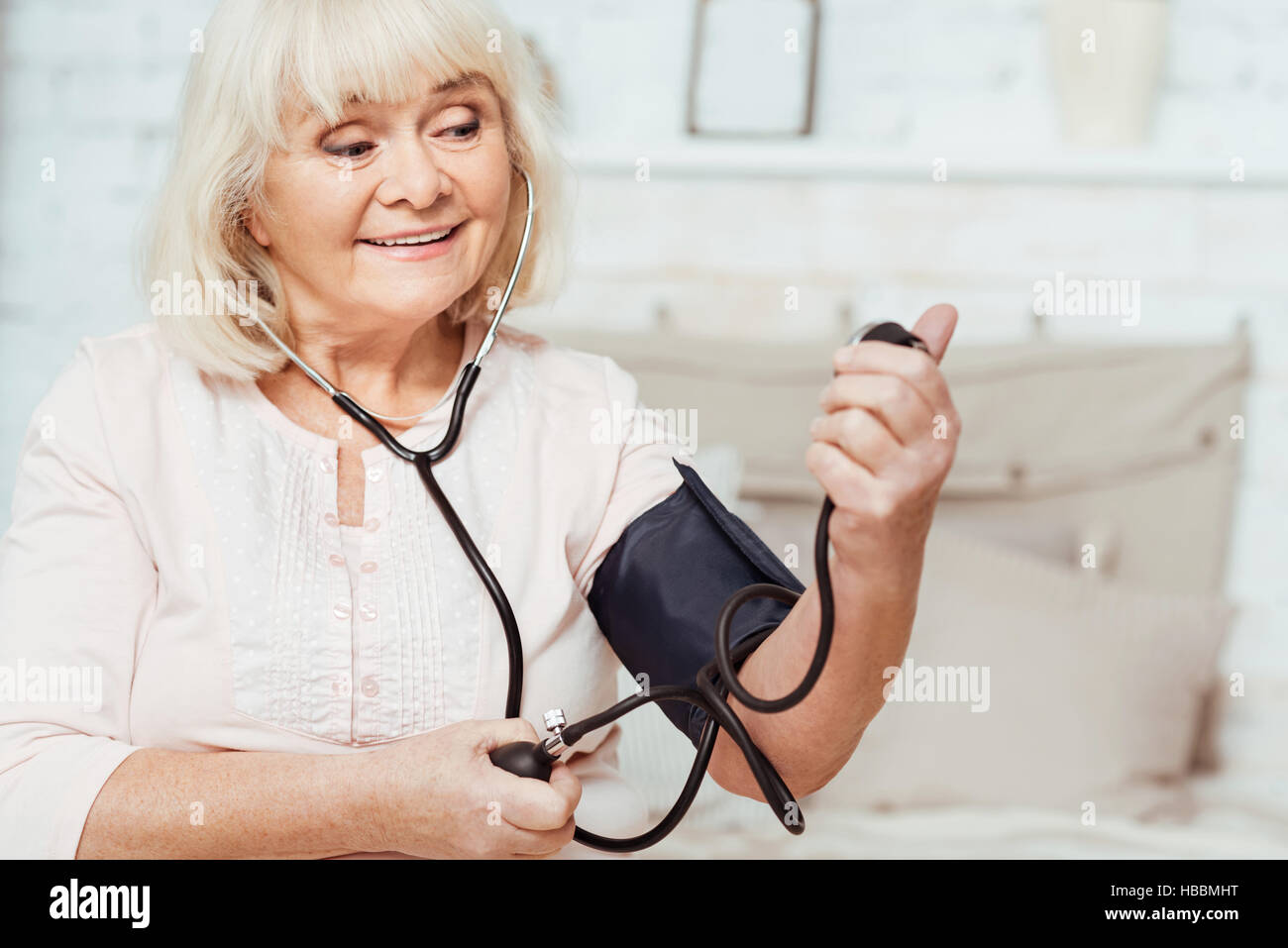 Aged smiling woman measuring blood pressure Stock Photo Alamy