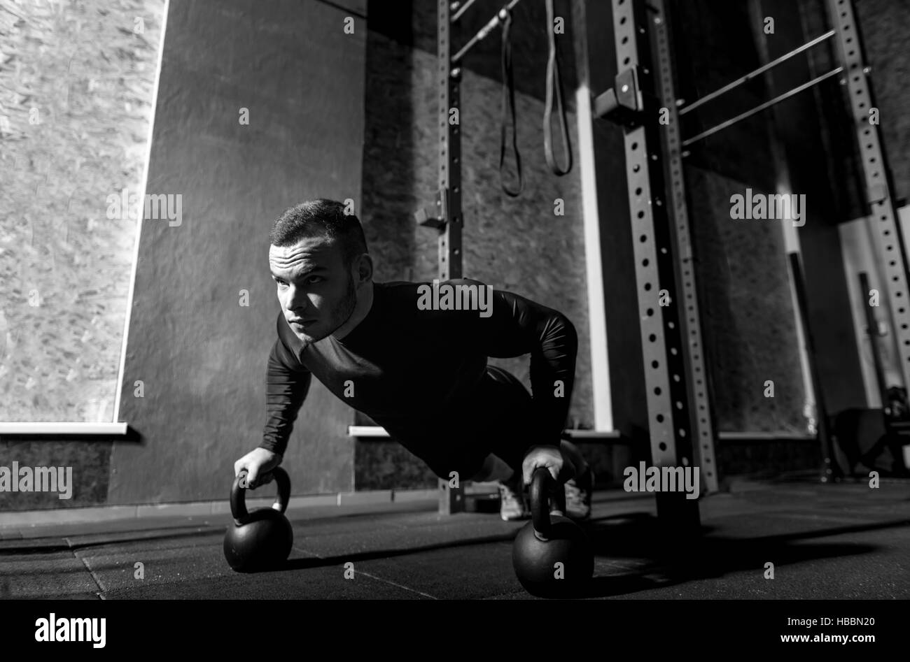 Well built brutal sportsman working out with kettlebells Stock Photo